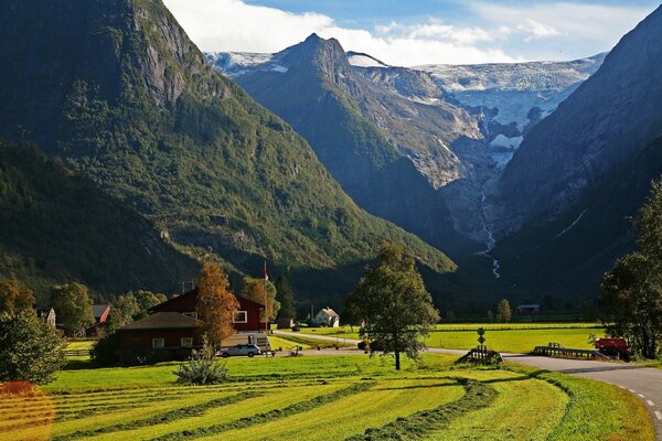 Mountain Norwegian landscape with a field and a house