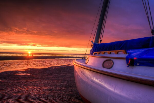 Yacht in der Nähe des Meeres vor dem Hintergrund des Sonnenuntergangs