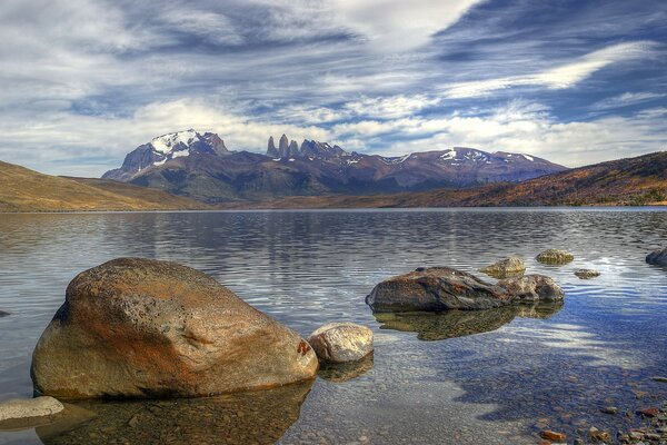 Piedras en el agua y en las montañas nieve