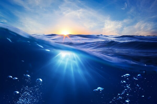 Bolle sott acqua e raggi del tramonto sull oceano