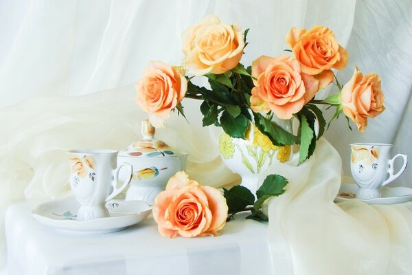 A snow-white tablecloth with delicate rosebuds, with a teapot and cups