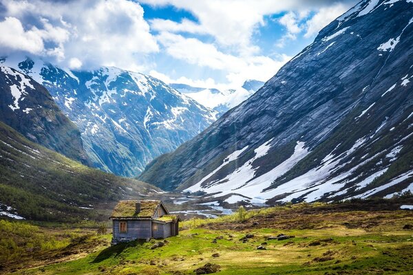 Norwegian landscape with snow-capped mountains and sunlight through clouds