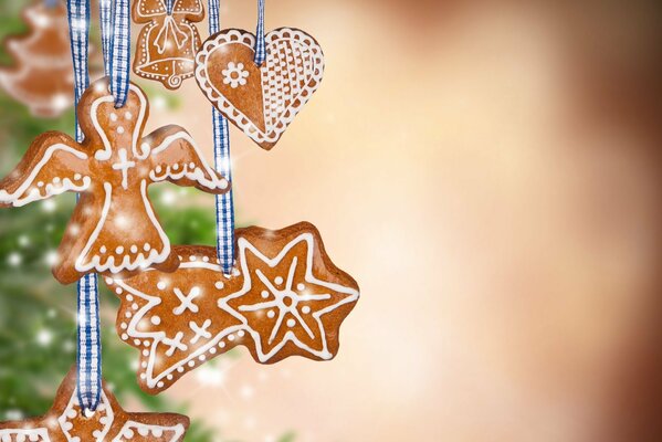 Ginger cookies in the shape of an angel, a bell, stars hanging on a Christmas tree