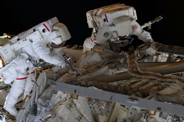 Astronauts perform work in open space