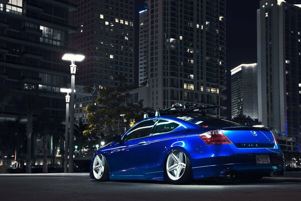 Voiture bleue Honda sur le fond de la ville de nuit