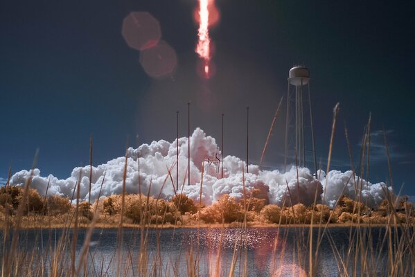 Rocket take-off against the background of a lake and ears of corn