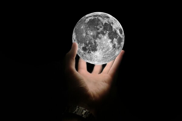 Ein schöner leuchtender Mond in der Hand eines Mannes