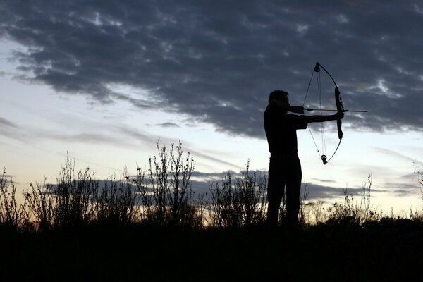 The silhouette of an archer in the predawn haze