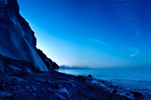 Bord de mer près des collines sous le clair de lune