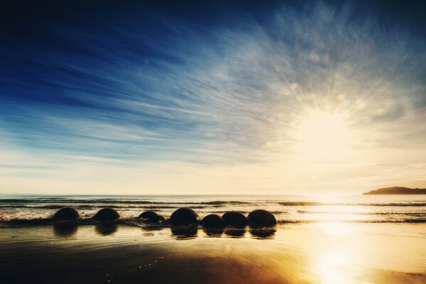 Lever du soleil sur la plage de l océan de la nouvelle-Zélande. Pierres dans les vagues