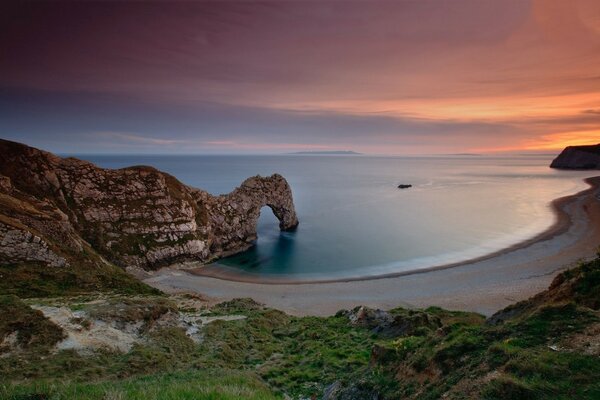 La costa al atardecer. Playa de arena