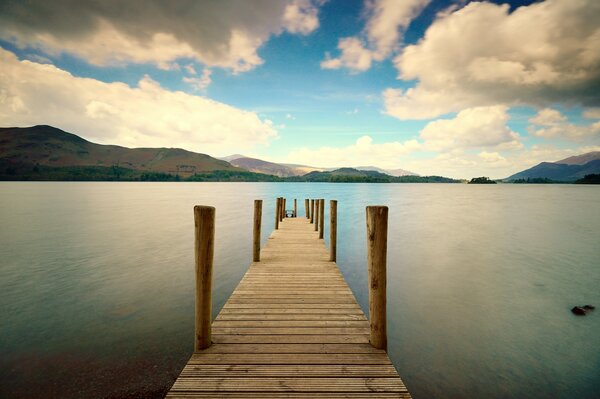 Wooden pier by the river to the mountains