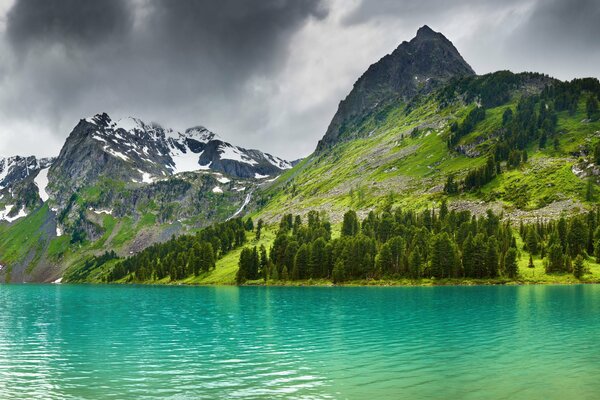 Lago de montaña en la cima de las montañas nevadas