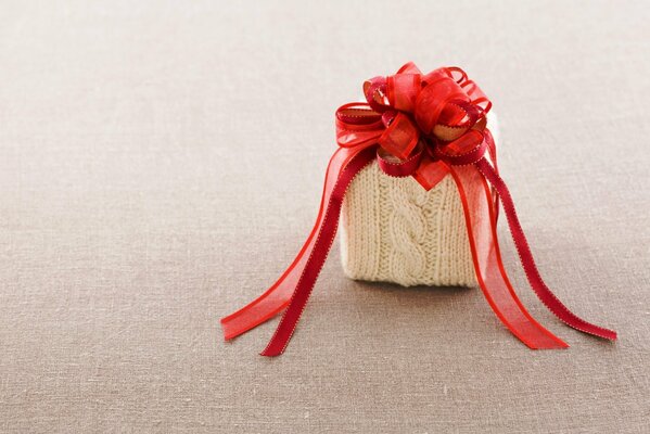 Knitted gift box with red bow