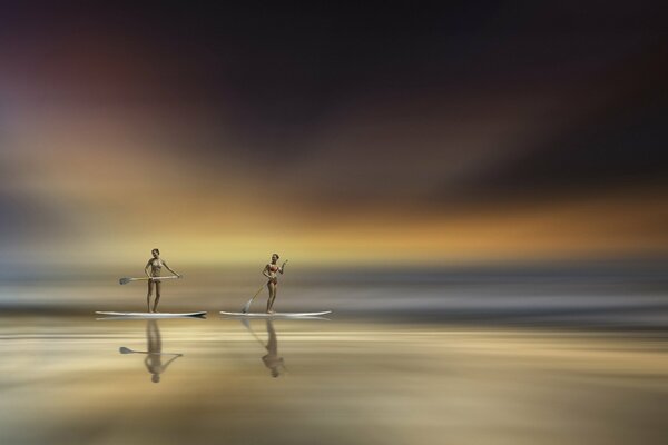 Two girls with oars in the sea