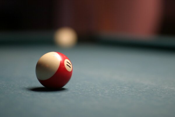 The red ball is lying on the billiard table