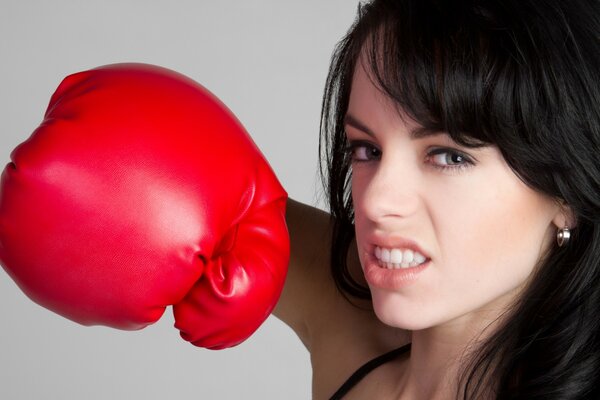 Aggressive girl in red boxing gloves