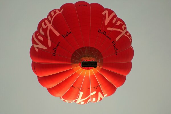 A red balloon is floating in the sky