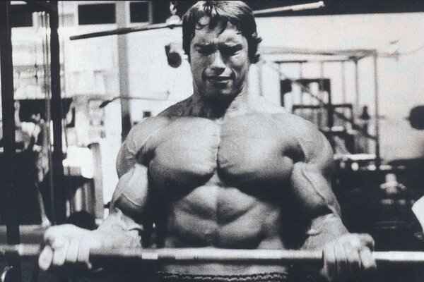 Young Arnold Schwarzenegger lifts the barbell