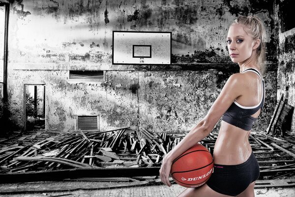 Ragazza con un pallone da basket su sfondo cupo