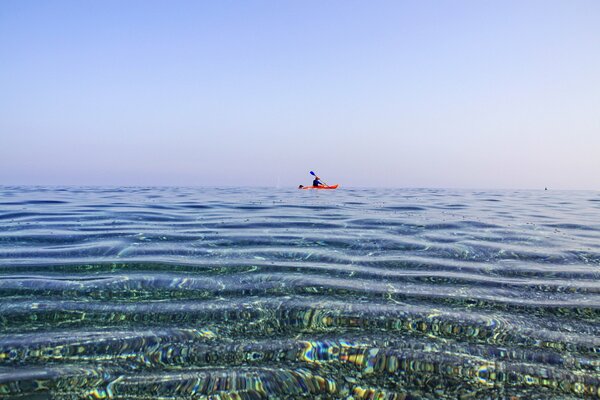 Homme en canoë nage dans la mer