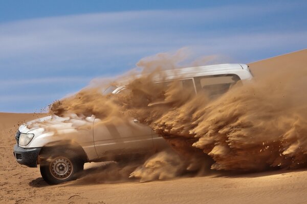 A white car in a sandy desert