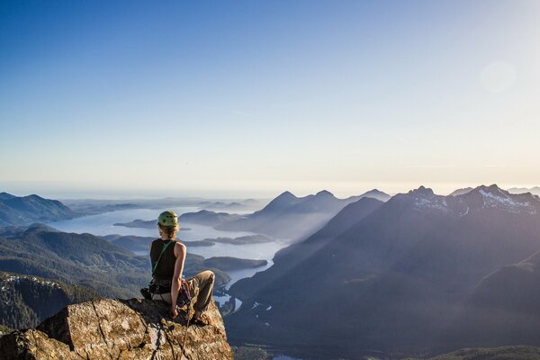 Fille assise sur fond de montagnes