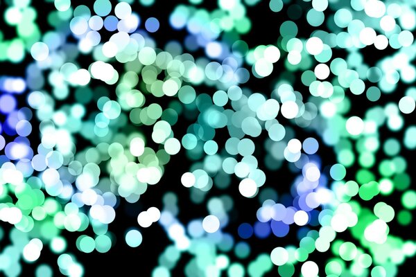 Der Bokeh-Effekt ist blau und grün auf schwarzem Hintergrund