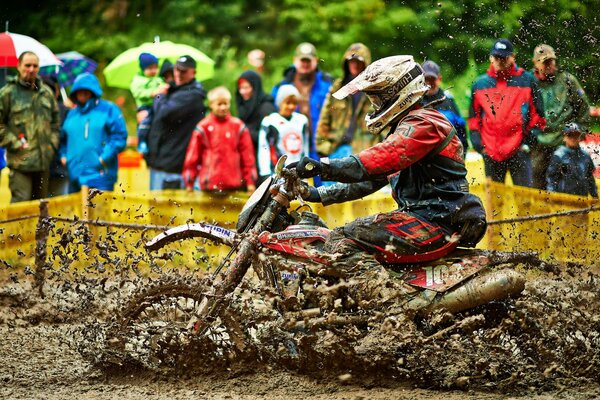 Un atleta su una moto cavalca nel fango