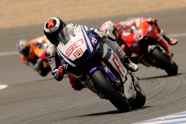 Tre motociclisti che guidano in pista