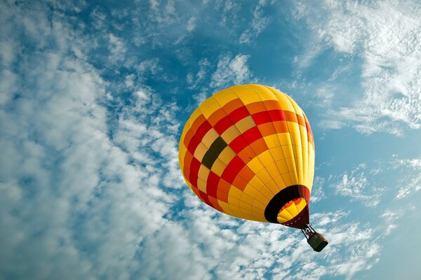 A balloon is flying high in the clouds