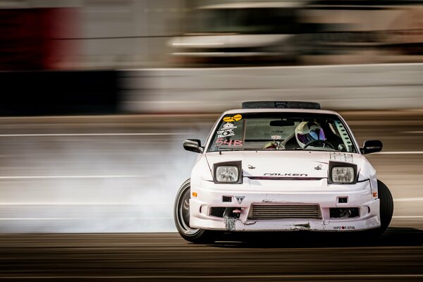 A racing driver drifts on a white racing car