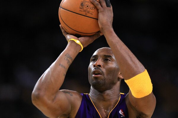 Basketball player Kobe Bryant is getting ready to throw the ball