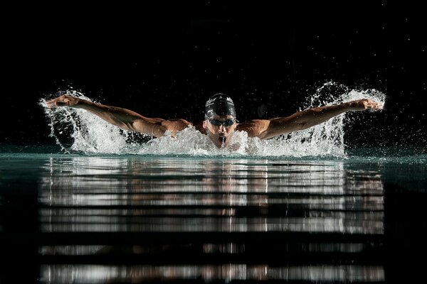 Der Schwimmer stieg aus dem Wasser, um die Luft einzuatmen