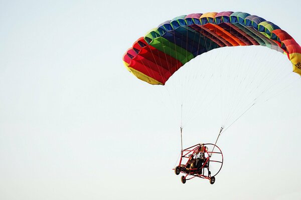 Ein mehrfarbiger Fallschirm schwebt am Himmel