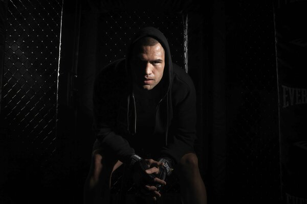 A man in a hood on a dark background