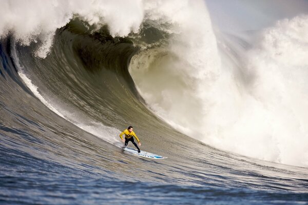 Un surfista en una tabla de surf monta una ola