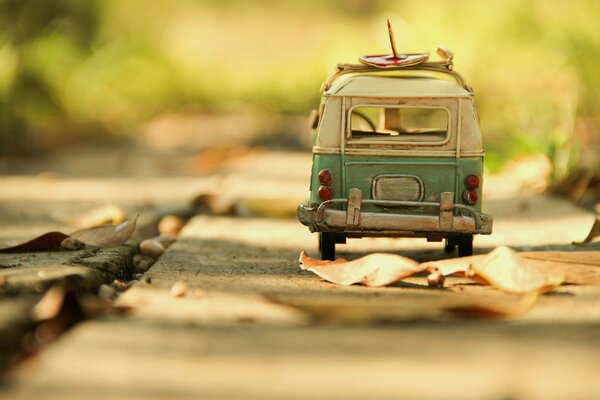 A small bus on the road with leaves