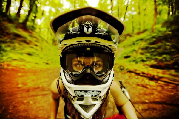 A girl in a helmet on a bicycle in the woods