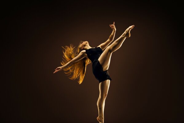 Fille aux cheveux roux dans la danse passionnément fond sombre