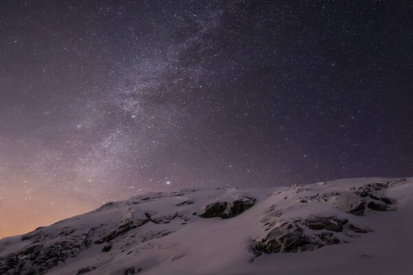 Photo du ciel étoilé et des montagnes enneigées