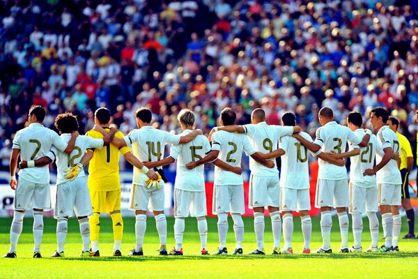 El equipo del real Madrid escucha el himno antes del partido de fútbol