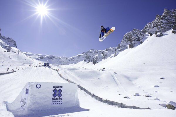 A snowboarder in flight on a snow descent