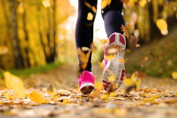 Zapatillas deportivas de color rosa para niñas en el parque de otoño