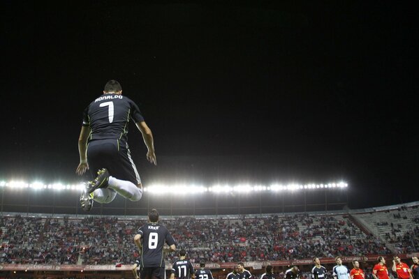 Joueur de football au saut au-dessus du stade