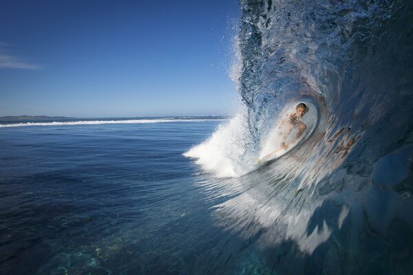 A windsurfing athlete glides on a wave