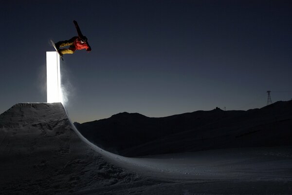 Salto con gli sci su uno snowboard in una tranquilla notte d inverno