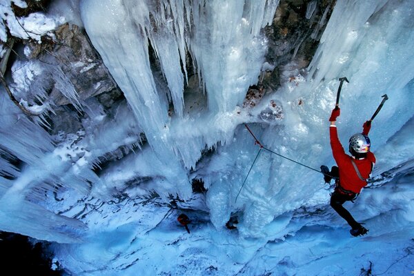 Foto profesional de un escalador de roca en invierno en las montañas heladas