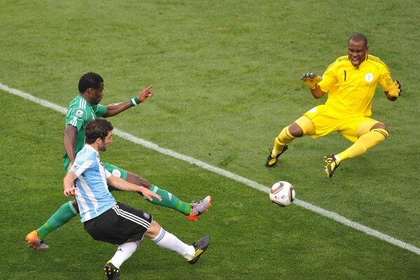 Three football players with a ball on the field. World Cup