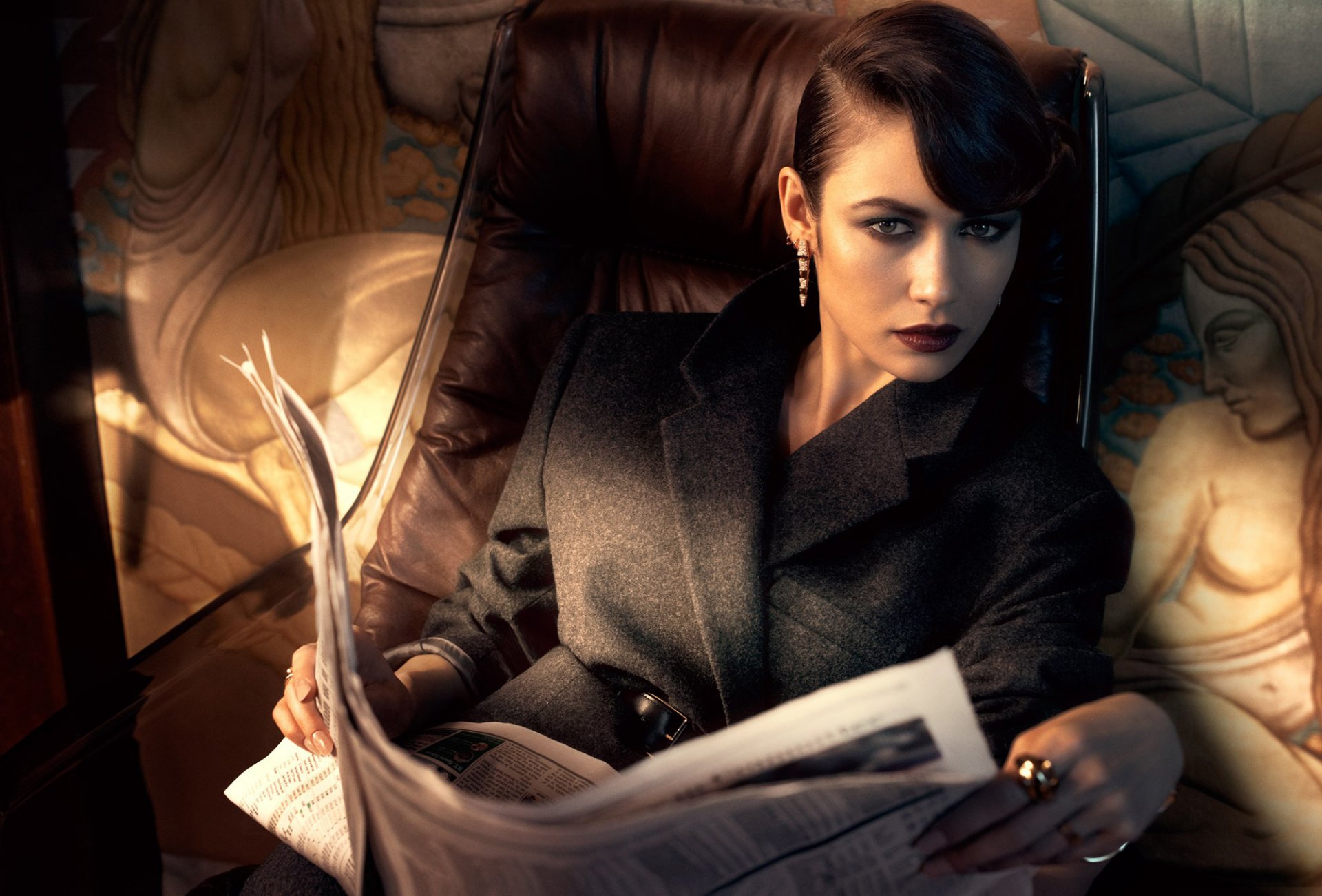 olga kurylenko modèle actrice brunette look coiffure maquillage manteau journal fauteuil séance photo magazine vanity fair photographe michelangelo di battista